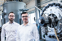 Michael Buchberger, Sales Manager, und Christoph Wöss, Business Development Manager für den Bereich Bottle bei EREMA, vor der VACUREMA® in der Produktionshalle bei EREMA. Die Inbetriebnahme bei AMUT ist für Anfang Mai vorgesehen.